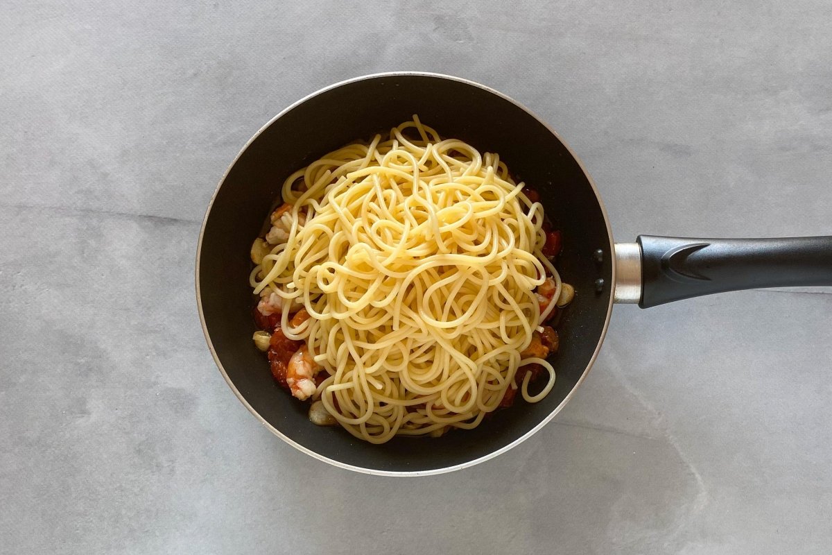 Mezclar el frutti di mare con los espaguettis *