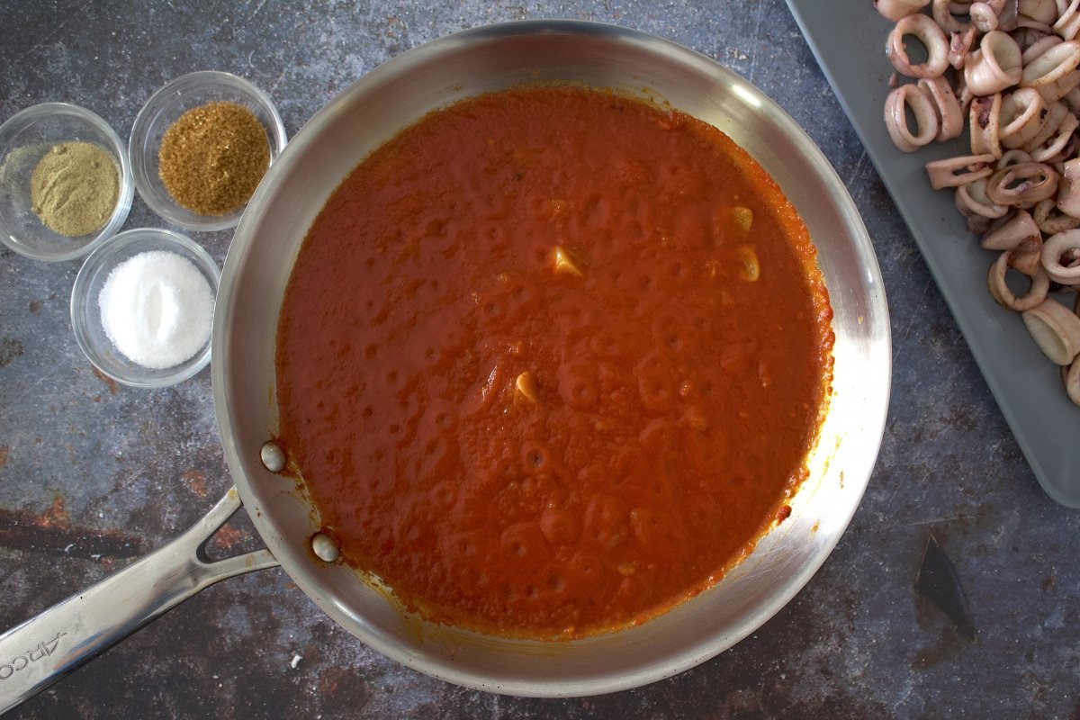 Salsa de tomate de los calamares en salsa de tomate en la sartén